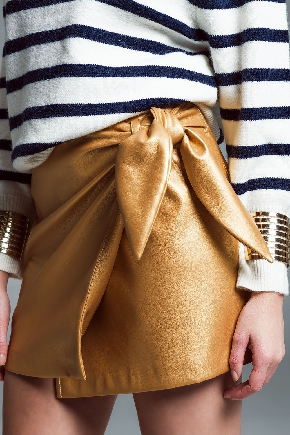 Μίνι φούστα από ψεύτικο δέρμα με φιόγκο στο πλάι σε χρυσό χρώμα